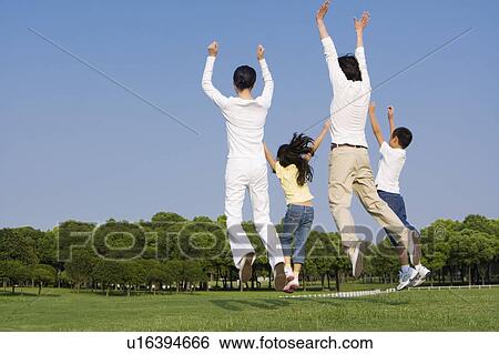 Family with two children jumping on the lawn View Large Photo Image Stock Photograph - Family with two children jumping on the lawn. Fotosearch