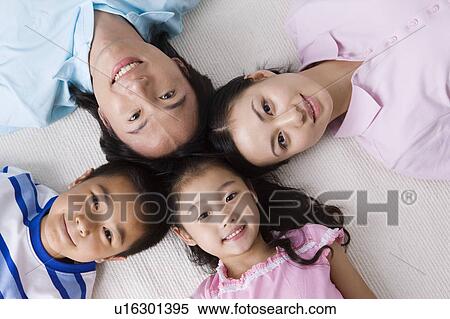 Stock Photography - Family with two children lying together and looking at the camera. Fotosearch