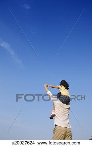 Picture - Father carrying daughter on shoulders. Fotosearch