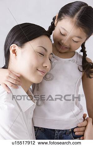 Stock Image - Mother and daughter embracing each other. Fotosearch