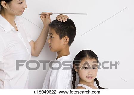 Mother measuring the height of two children View Large Photo Image Stock Image - Mother measuring the height of two children. Fotosearch