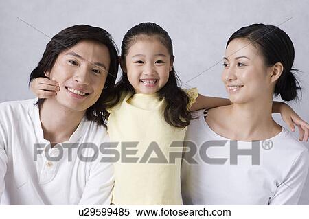 Stock Photography - Young family with daughter looking at the camera and smiling happily. Fotosearch