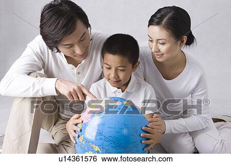 Young family with son looking at the globe View Large Photo Image Stock Photograph - Young family with son looking at the globe. Fotosearch
