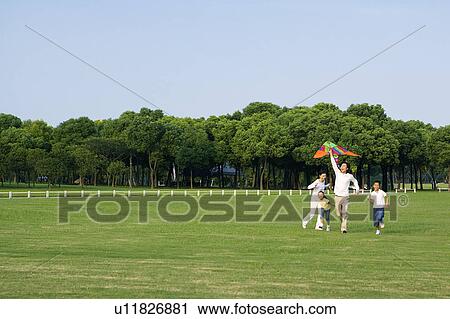 Young family with two children flying a kite on the lawn View Large Photo Image Stock Image - Young family with two children flying a kite on the lawn. Fotosearch