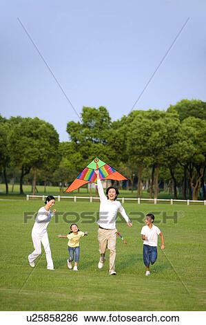 Young family with two children flying a kite on the lawn View Large Photo Image Stock Photograph - Young family with two children flying a kite on the lawn. Fotosearch