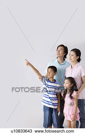 Young family with two children looking away and standing together View Large Photo Image Stock Image - Young family with two children looking away and standing together. Fotosearch