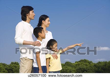 Stock Image - Young family with two children looking away. Fotosearch
