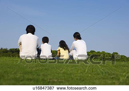 Young family with two children sitting on the lawn View Large Photo Image Stock Photo - Young family with two children sitting on the lawn. Fotosearch