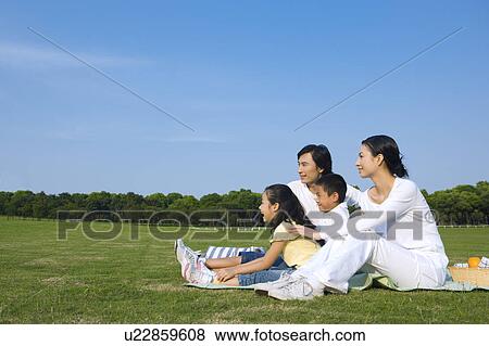 Young family with two children sitting on the lawn View Large Photo Image Stock Photo - Young family with two children sitting on the lawn. Fotosearch