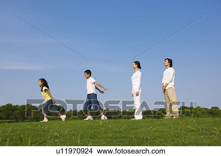 Young family with two children standing on the lawn View Large Photo Image Picture - Young family with two children standing on the lawn. Fotosearch