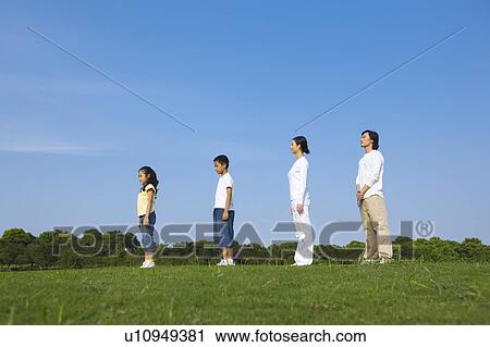 Young family with two children standing on the lawn, in a row View Large Photo Image Stock Image - Young family with two children standing on the lawn, in a row. Fotosearch