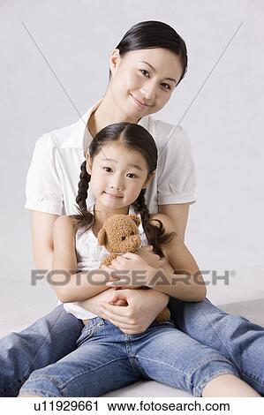 Stock Image - Young mother holding daughter. Fotosearch