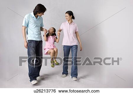 Young parents lifting up their daughter View Large Photo Image Stock Photograph - Young parents lifting up their daughter. Fotosearch