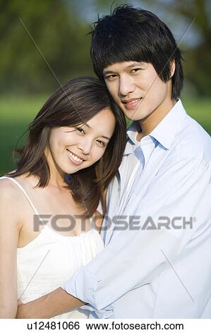 Young couple bonding together and looking at the camera View Large Photo Image Stock Photograph - Young couple bonding together and looking at the camera. Fotosearch
