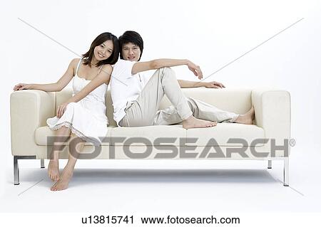 Young couple bonding together on the sofa View Large Photo Image Stock Image - Young couple bonding together on the sofa. Fotosearch