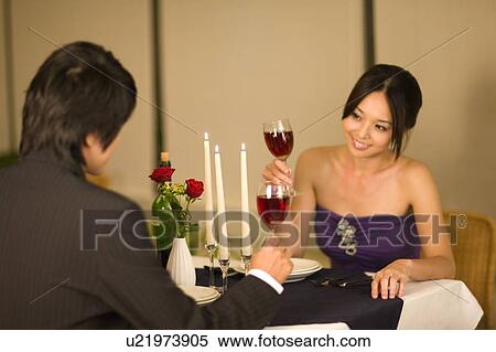 Young couple looking at each other and holding a glass of red wine View Large Photo Image Stock Photography - Young couple looking at each other and holding a glass of red wine. Fotosearch