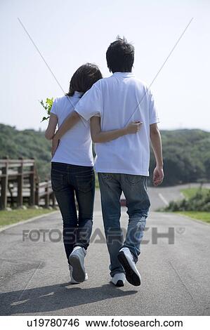 Young couple walking on the road, rear view View Large Photo Image Stock Photograph - Young couple walking on the road, rear view. Fotosearch
