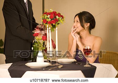 Young man giving a bunch of flowers to his girlfriend View Large Photo Image Stock Photo - Young man giving a bunch of flowers to his girlfriend. Fotosearch