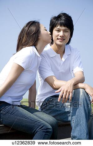 Stock Photo - Young woman closing eyes and kissing at the young man. Fotosearch