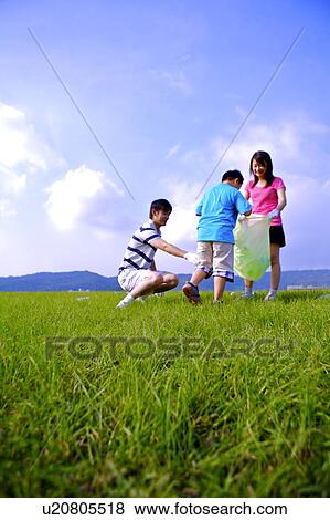 Family with one child putting the empty bottles into the garbage bag View Large Photo Image Stock Photo - Family with one child putting the empty bottles into the garbage bag. Fotosearch
