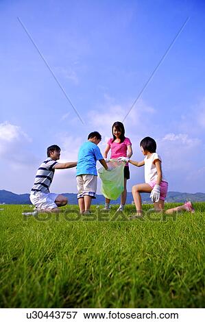 Family with two children putting the empty bottles into the garbage bag View Large Photo Image Stock Photo - Family with two children putting the empty bottles into the garbage bag. Fotosearch