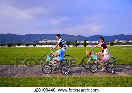 Stock Photo - Family with two children riding on the bicycles together. Fotosearch