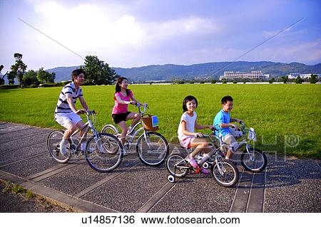 Family with two children riding on the bicycles together View Large Photo Image Stock Photograph - Family with two children riding on the bicycles together. Fotosearch