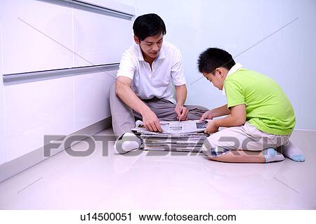 Father with one child sitting on the floor and packing the newspaper up View Large Photo Image Stock Image - Father with one child sitting on the floor and packing the newspaper up. Fotosearch