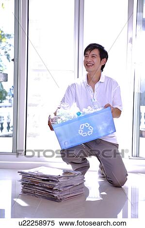 Man holding a recycling bin, looking away and smiling View Large Photo Image Stock Photography - Man holding a recycling bin, looking away and smiling. Fotosearch