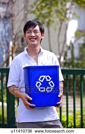 Man holding the recycling bin and smiling happily View Large Photo Image Stock Photograph - Man holding the recycling bin and smiling happily. Fotosearch
