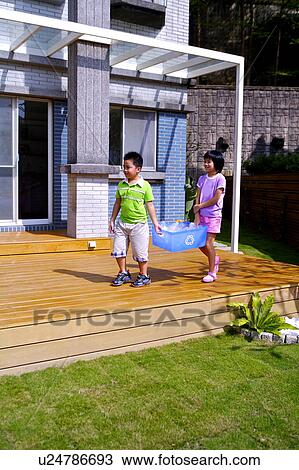 Two children holding the recycling bin together View Large Photo Image Stock Image - Two children holding the recycling bin together. Fotosearch