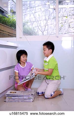 Stock Photography - Two children packing up the newspaper together. Fotosearch