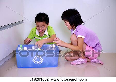 Two children sitting on the floor and putting empty bottles into the recycling bin View Large Photo Image Stock Image - Two children sitting on the floor and putting empty bottles into the recycling bin. Fotosearch