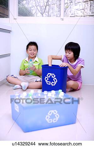 Two children sittong on the floor and holding the recycling bin and empty bottle View Large Photo Image Picture - Two children sittong on the floor and holding the recycling bin and empty bottle. Fotosearch