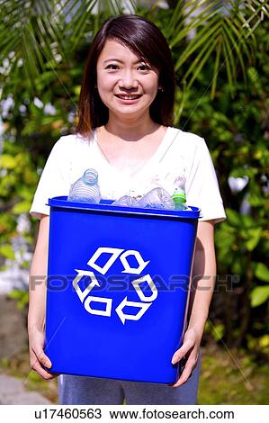 Woman holding a recycling bin with empty bottles and looking at the camera View Large Photo Image Stock Image - Woman holding a recycling bin with empty bottles and looking at the camera. Fotosearch