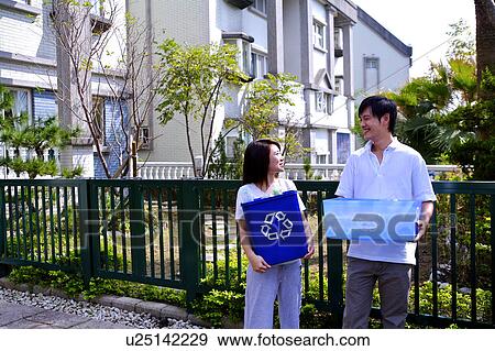 Young couple holding the recycling bins and looking at each other View Large Photo Image Stock Photo - Young couple holding the recycling bins and looking at each other. Fotosearch