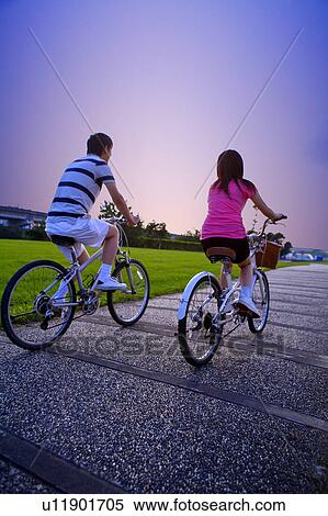 Stock Photography - Young couple riding on the bicycles together. Fotosearch