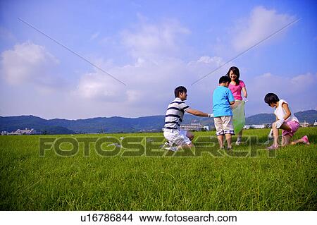 Young family with two children recycling wasted bottles on grass View Large Photo Image Picture - Young family with two children recycling wasted bottles on grass. Fotosearch