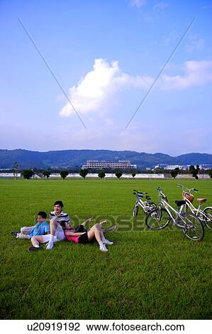 Young family with two children sitting and lying on the lawn View Large Photo Image Stock Image - Young family with two children sitting and lying on the lawn. Fotosearch