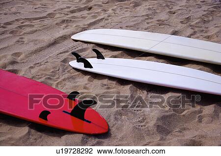 Stock Image - Close-up of three surfboards on beach. Fotosearch