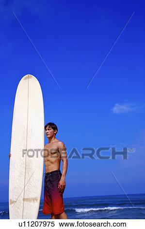 Man holding the surfboard and looking away View Large Photo Image Stock Photography - Man holding the surfboard and looking away. Fotosearch