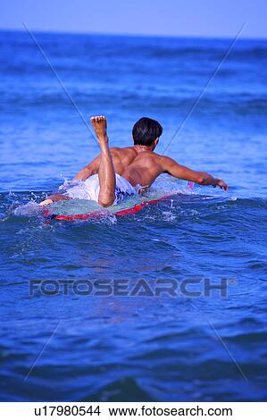 Picture - Man floating on the sea with the surfboard. Fotosearch