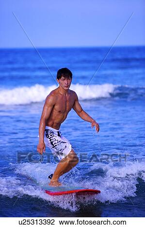 Stock Image - Man surfing on the sea skillfully. Fotosearch