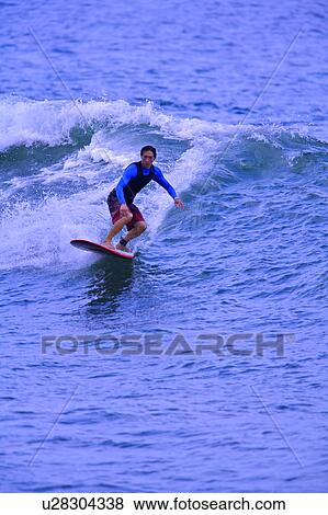 Stock Photo - Man surfing on the sea skillfully. Fotosearch