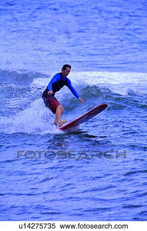 Stock Photography - Man surfing on the sea skillfully. Fotosearch