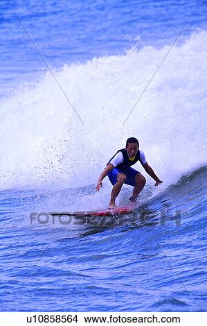 Man surfing on the sea skillfully with huge surf behind View Large Photo Image Picture - Man surfing on the sea skillfully with huge surf behind. Fotosearch