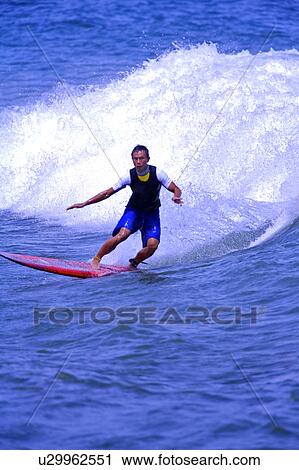 Man surfing on the sea skillfully with huge surf behind View Large Photo Image Stock Image - Man surfing on the sea skillfully with huge surf behind. Fotosearch