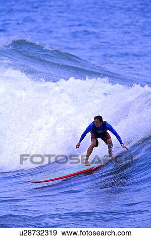 Stock Photo - Man surfing on the sea skillfully with surf around. Fotosearch