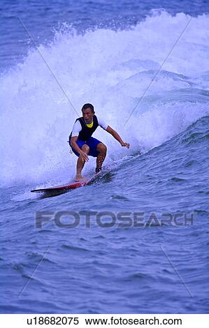 Stock Photography - Man surfing on the sea skillfully with surf behind. Fotosearch