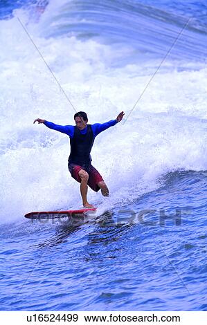 Man surfing on the sea with arms outstretched View Large Photo Image Stock Photo - Man surfing on the sea with arms outstretched. Fotosearch